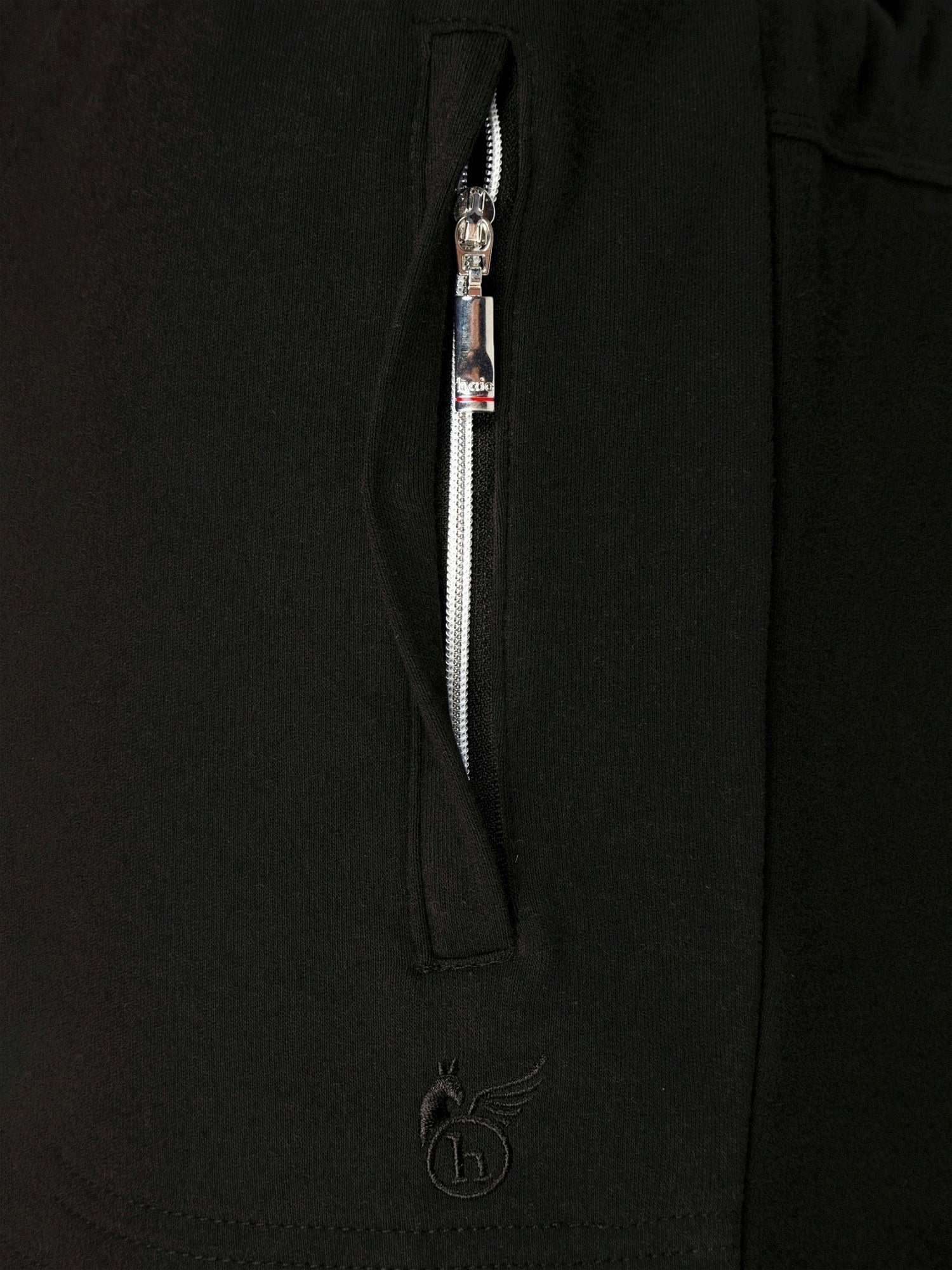 Schwarze Reißverschlussjacke mit silbernem Reißverschluss und Logo.