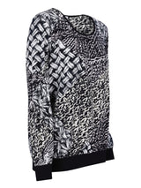 Schwarz-weißer gewebter Musterpullover mit gerippten Bündchen.