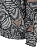 Schwarz-weißes Schal mit Blattmuster und texturierter, gewebter Optik.