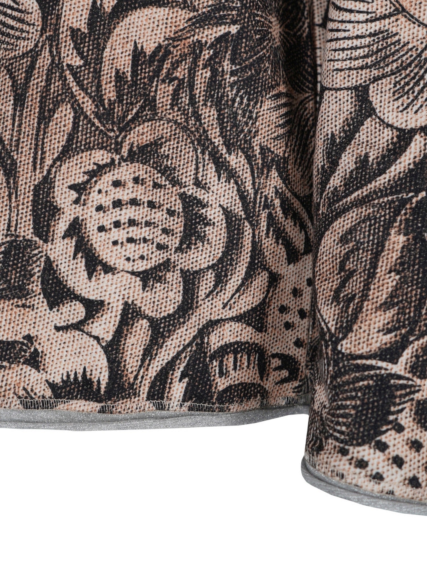 Blumiges Mustergewebe-Kissen mit schwarz-weißem Design auf beigem Hintergrund.