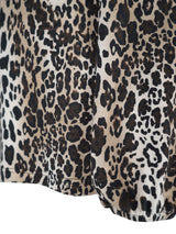 Leopardmuster-Stoffjacke mit schwarzen und braunen Flecken auf beigem Hintergrund.