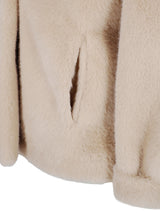 Cremeweißer Fellmantel mit texturierter, plüschiger Optik und vertikaler Naht.