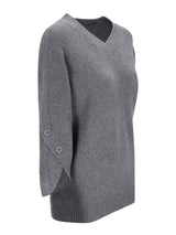Grauer pullover 3/4 arm mit v-ausschnitt, rippenbündchen und zwei knöpfen am ärmel aus weichem material