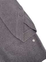 Grauer strick pullover mit 3/4 arm, gerippten bündchen und kragen, dunklen knöpfen und kleinem silbernem markenetikett