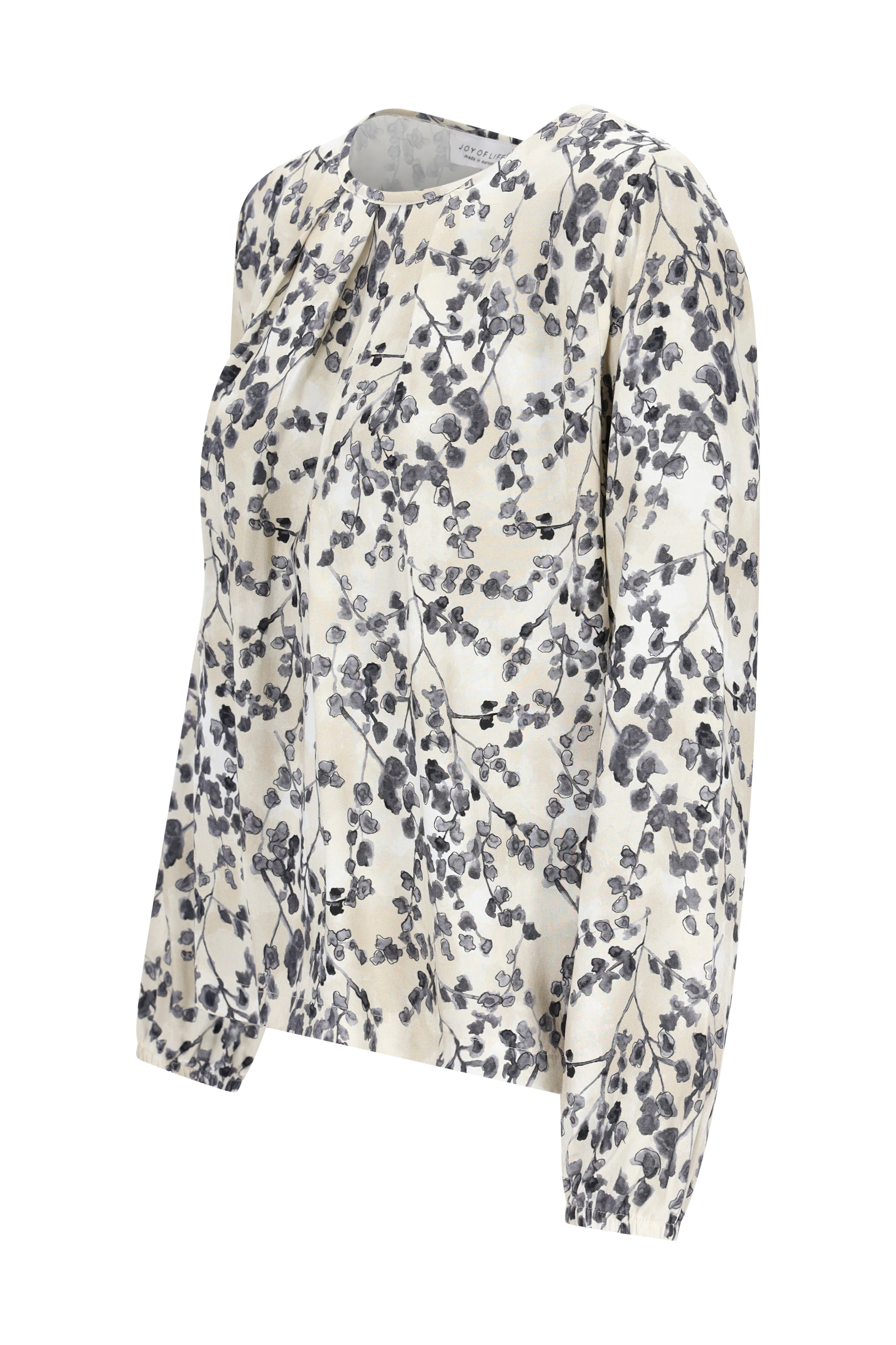 Eine zarte ivory bluse bedruckt mit schwarz-grauem floralmuster aus weich fließendem stoff und langen ärmeln
