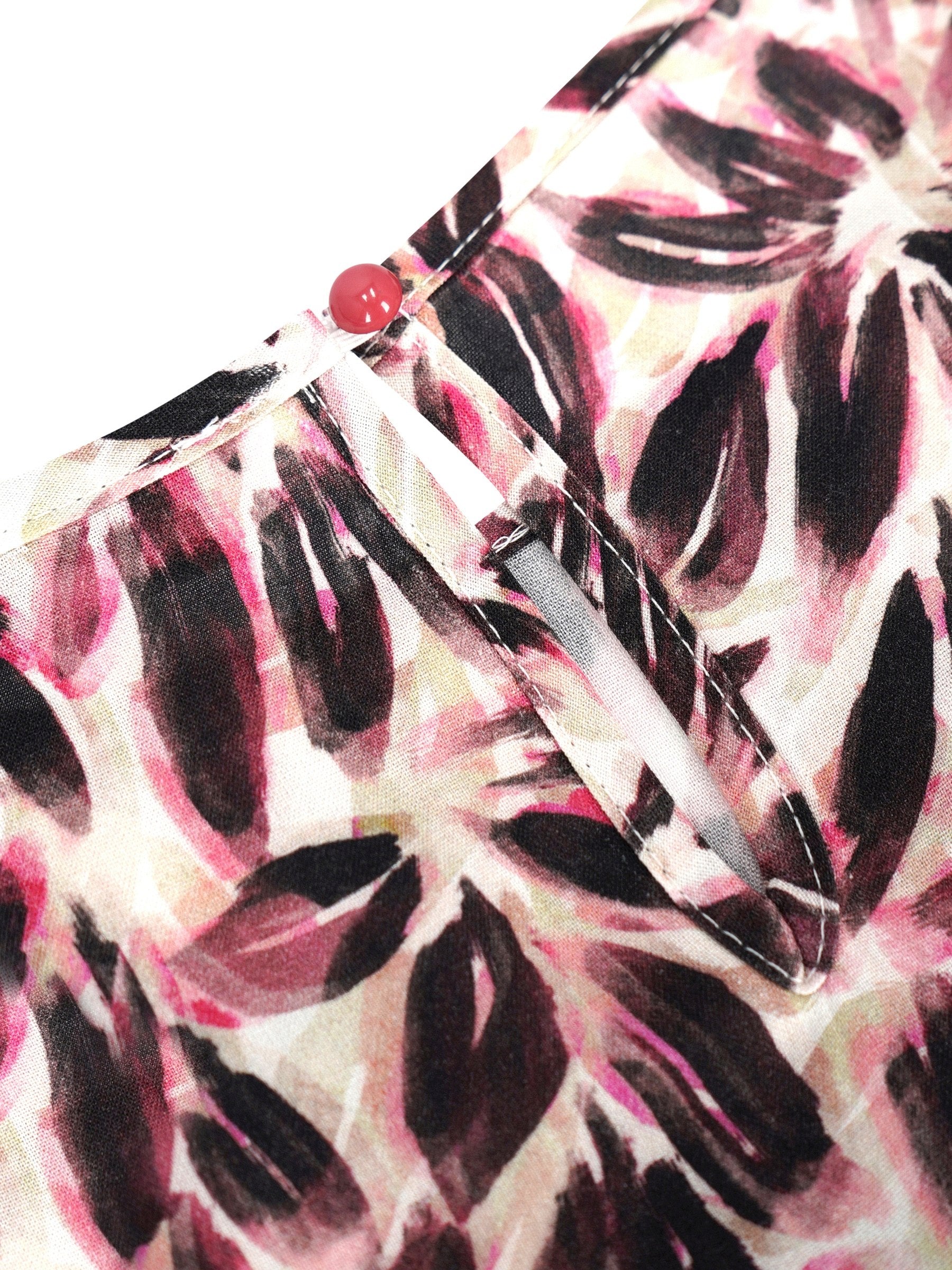 Bluse blütenprint aus rosa und schwarzem blattmusterstoff mit rotem knopfsverschluss