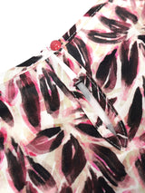 Bluse blütenprint aus rosa und schwarzem blattmusterstoff mit rotem knopfsverschluss
