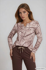 Ein soft touch shirt soft rosa langärmelig mit zartem silberbesatz am hals und abstraktem linienmuster