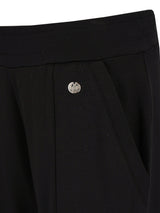 Schwarze maßgeschneiderte Hosen mit silberner Knopfdetail.