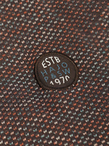 Rund bestickter patch mit weißer und hellblauer schrift auf dunkelbraunem stehkragen-sweatshirt mit spots-allover