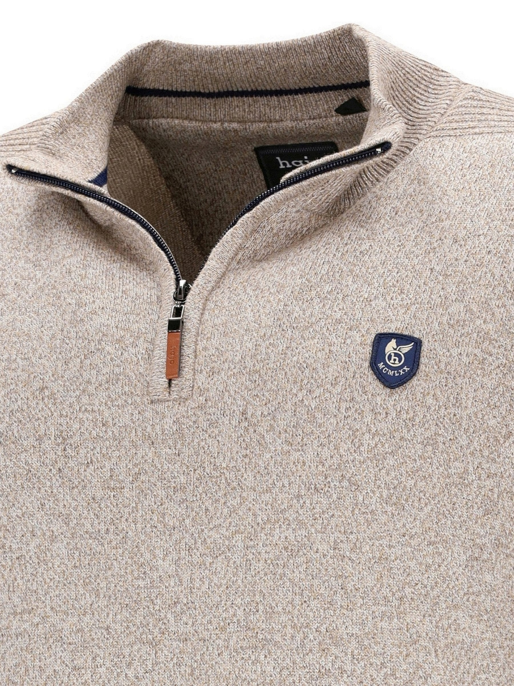 Beige Viertelreißverschluss-Pullover mit marineblauem Logo und Reißverschlusszieher.