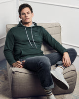 Dunkelgrüner Kapuzenpullover mit grauem Kordelzug.