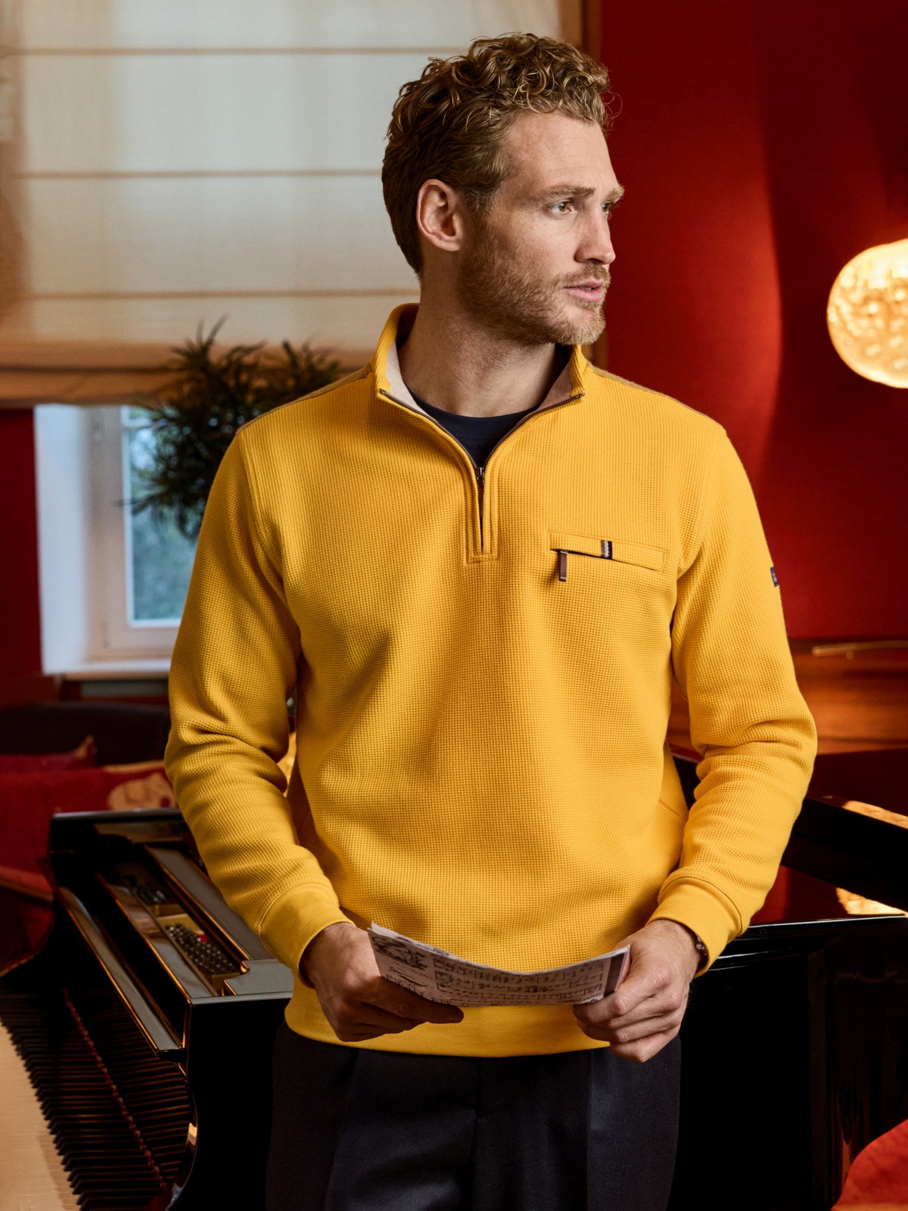 Ein gelber troyersweatshirt mit mini-waffelstruktur allover, kontrastkragen und brusttasche aus strukturstrick