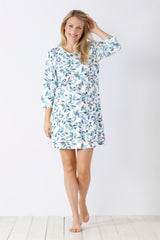 Ein weißes Nachthemd mit blauem und grünem Blattmuster und dreiviertellangen Ärmeln.