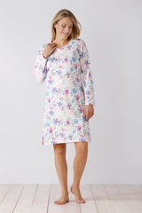 Weißes langärmeliges Nachthemd mit einem Blumenmuster in Rosa, Blau und Lila.