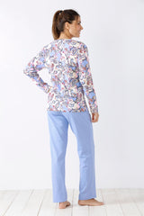 Frau trägt ein langärmeliges Oberteil mit Paisleymuster und eine hellblaue Pyjamahose.