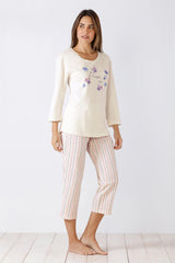 Weißes Damen-Pyjama-Oberteil mit blauer Blumenstickerei und gestreifter Capri-Pyjamahose.