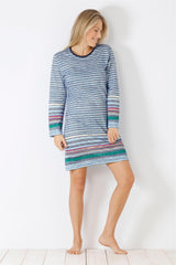 Eine Frau in einem blau und bunt gestreiften langärmeligen Nachthemd.