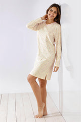 Ein langärmeliges, knielanges, cremefarbenes Nachthemd mit kleinen schwarzen Tupfen und V-Ausschnitt.