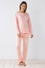 Ein hellrosa, langärmeliges Pyjama-Set mit dezentem, dunklem Blumenmuster und gerüschten Bündchen.