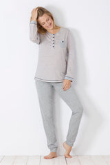 Gestreiftes langärmeliges Damen-Pyjama-Oberteil und einfarbige graue Pyjama-Hose.