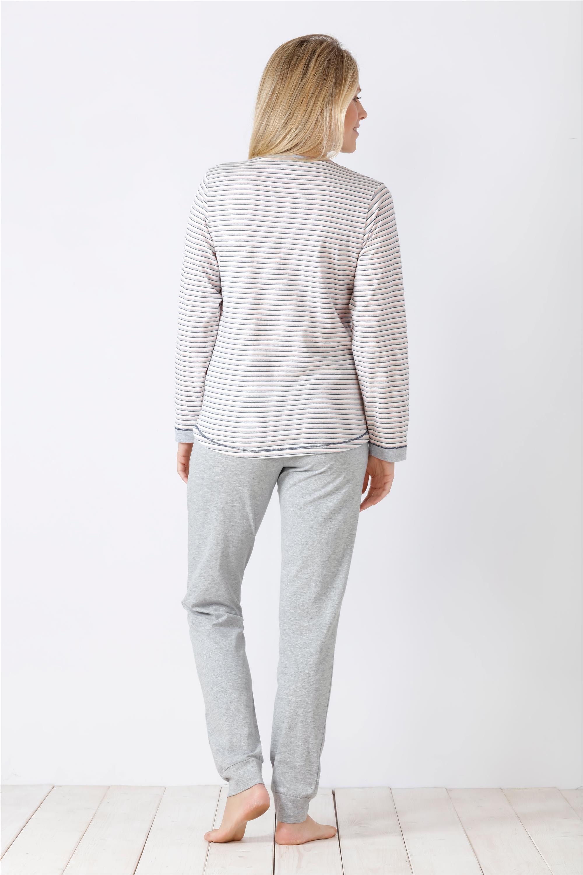 Eine Frau, die einen hellgrau gestreiften langärmeligen Schlafanzug trägt.
