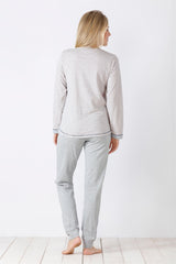 Eine Frau, die einen hellgrau gestreiften langärmeligen Schlafanzug trägt.