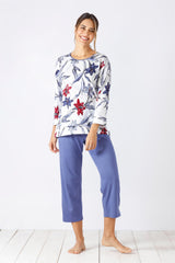 Weißes langärmeliges Oberteil mit Blumendruck und blaues Capri-Pyjama-Set für Damen.