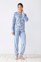 Eine junge Frau in einem hellblauen Pyjama mit Paisleymuster.