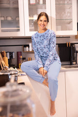 Eine junge Frau in einem hellblauen Pyjama mit Paisleymuster.