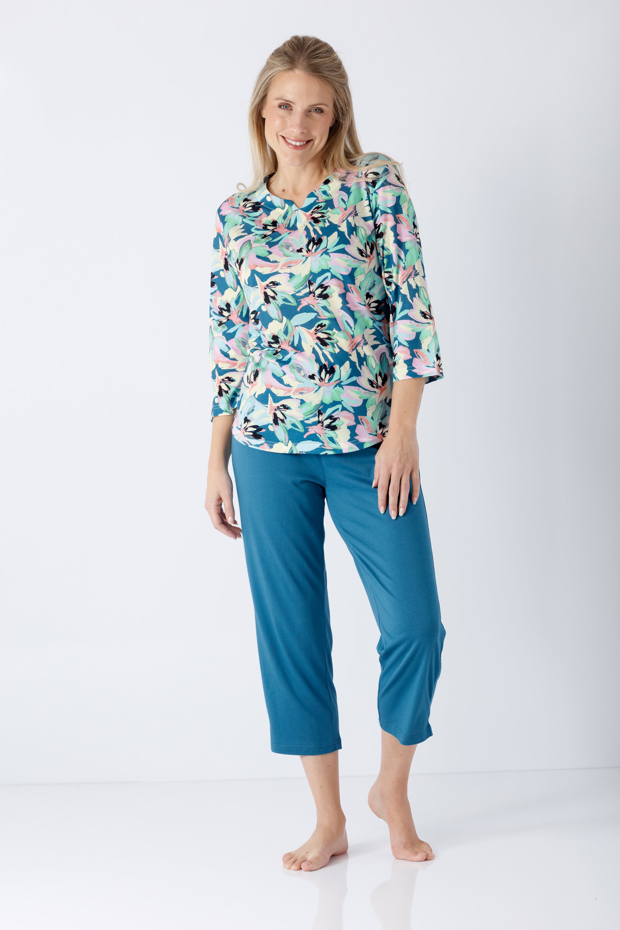 Eine frau trägt einen teal floral bedruckten damen schlafanzug 7/8 aus premium baumwolle und TENCEL™ modal