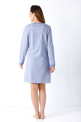 Eine Frau trägt ein langärmeliges damen sleepshirt mit feinen hellblauen und weißen Streifen aus Premium Baumwolle