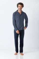 Mann trägt navyblauen nos herren schlafanzug pyjama aus premium baumwolle mit gemustertem oberteil und einfarbiger hose