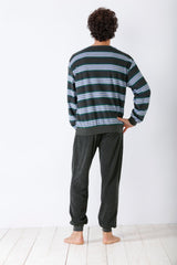 Eine Person von hinten, die einen dunkel gestreiften Pyjama trägt.