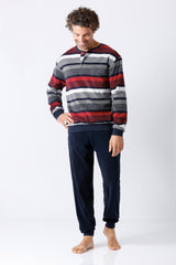 Mann trägt herren schlafanzug mit bündchen frottee in gestreiftem langarmshirt rot grau weiß und navy blaue samtige hose