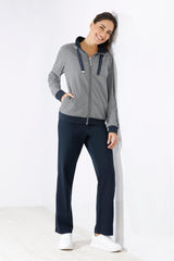 Gestreifte Kapuzenjacke mit Reißverschluss für Damen mit marineblauem Saum und passender dunkelblauer Hose.