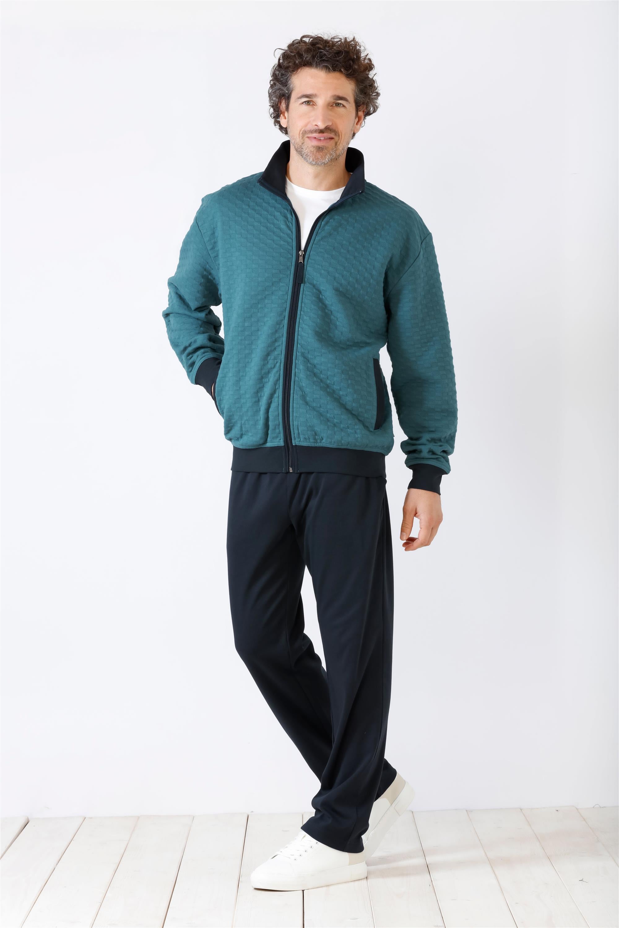 Tealfarbene Trainingsjacke mit durchgehendem Reißverschluss und schwarze Jogginghose für Männer.