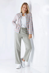 Frau in Damen Freizeitanzug mit pastellrosa-blau gestreiftem Jackett