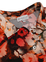 Bluse mit Blumenmuster, Knöpfen vorne und Kragen, mit einer lebendigen Mischung aus Rot-, Orange-, Pink- und Schwarztönen auf weichem Stoff.