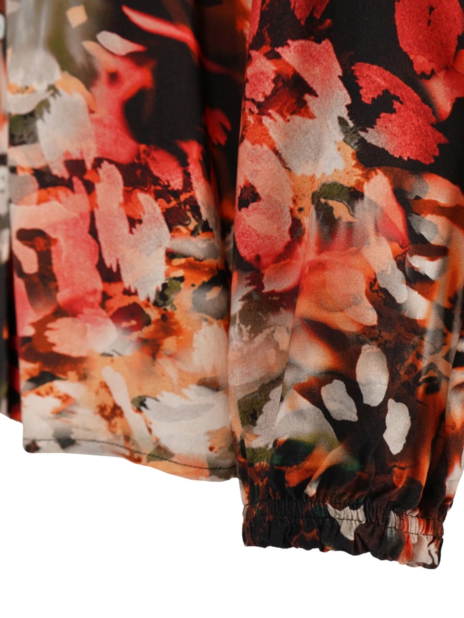 Jogginghose mit Blumenmuster in Orange-, Rot- und Weißtönen auf schwarzem Hintergrund.
