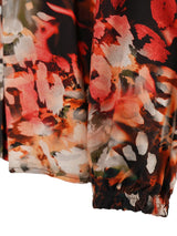 Jogginghose mit Blumenmuster in Orange-, Rot- und Weißtönen auf schwarzem Hintergrund.
