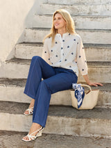 Beige Ledertasche mit blau-weiß gemustertem Schal am Henkel