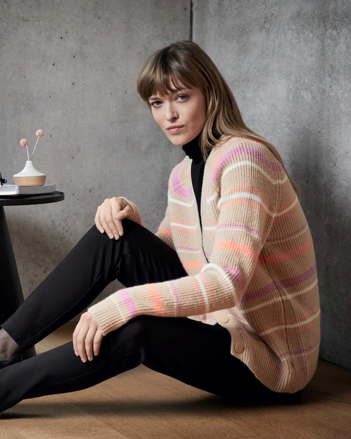 Beige und rosa karierter Strickpullover mit schwarzem Rollkragen darunter.