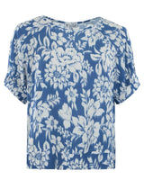 Blaue und weiße geblümte Bluse mit kurzen Ärmeln.