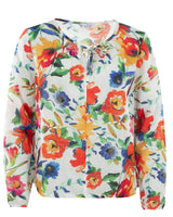 Florale Bluse mit leuchtenden orangefarbenen, blauen und gelben Blüten auf weißem Hintergrund.