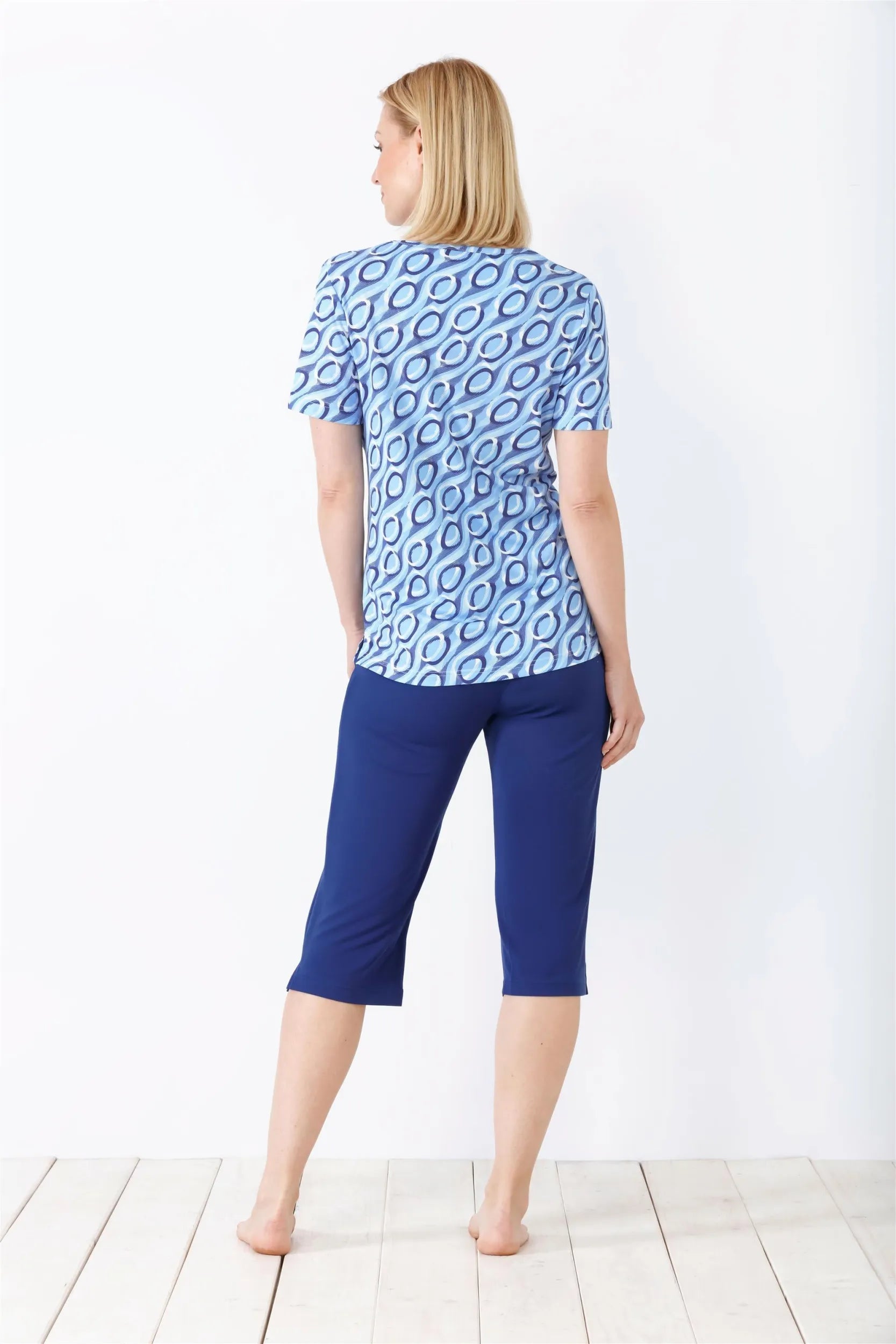 Blau gemustertes kurzärmeliges Oberteil und marineblaue Caprihose für Damen.