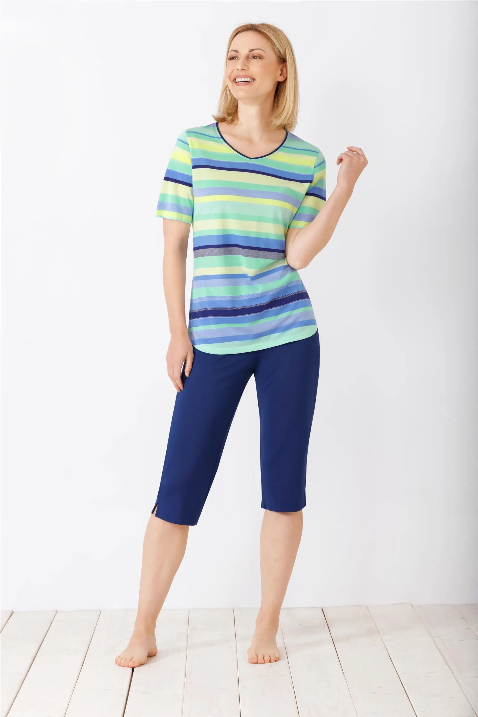 Gestreiftes kurzärmeliges Damenoberteil und marineblaue Caprihose