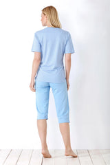 Hellblaues Damen-Pyjama-Set mit gemustertem, kurzärmeligem Oberteil und Capri-Hose.