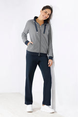 Gestreifte Kapuzenjacke mit Reißverschluss für Damen mit marineblauem Saum und passender dunkelblauer Hose.