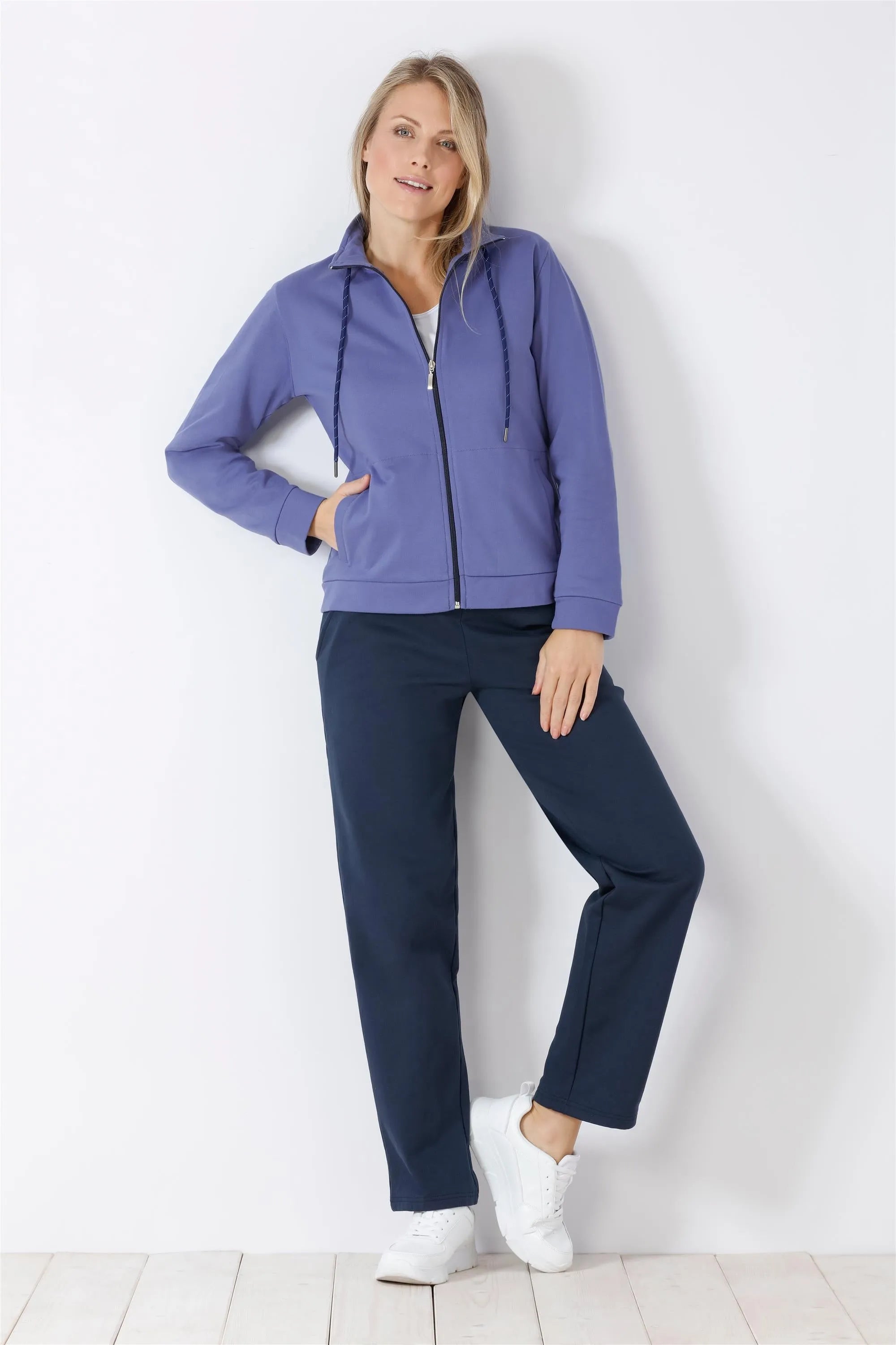 Lila Kapuzenpulli mit Reißverschluss und marineblaue Jogginghose für Frauen.